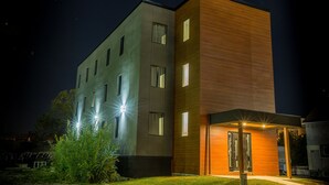 A modern building with multiple windows and a garage entrance. - Clifton Hill Condo's (Niagara Falls)