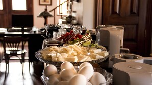 A buffet table with various food items including cheese, eggs, and vegetables.