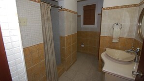 A bathroom with a shower, toilet, sink, and towel rack. - San Cove, Blue Lagoon, Port Antonio 4BR (Port Antonio)