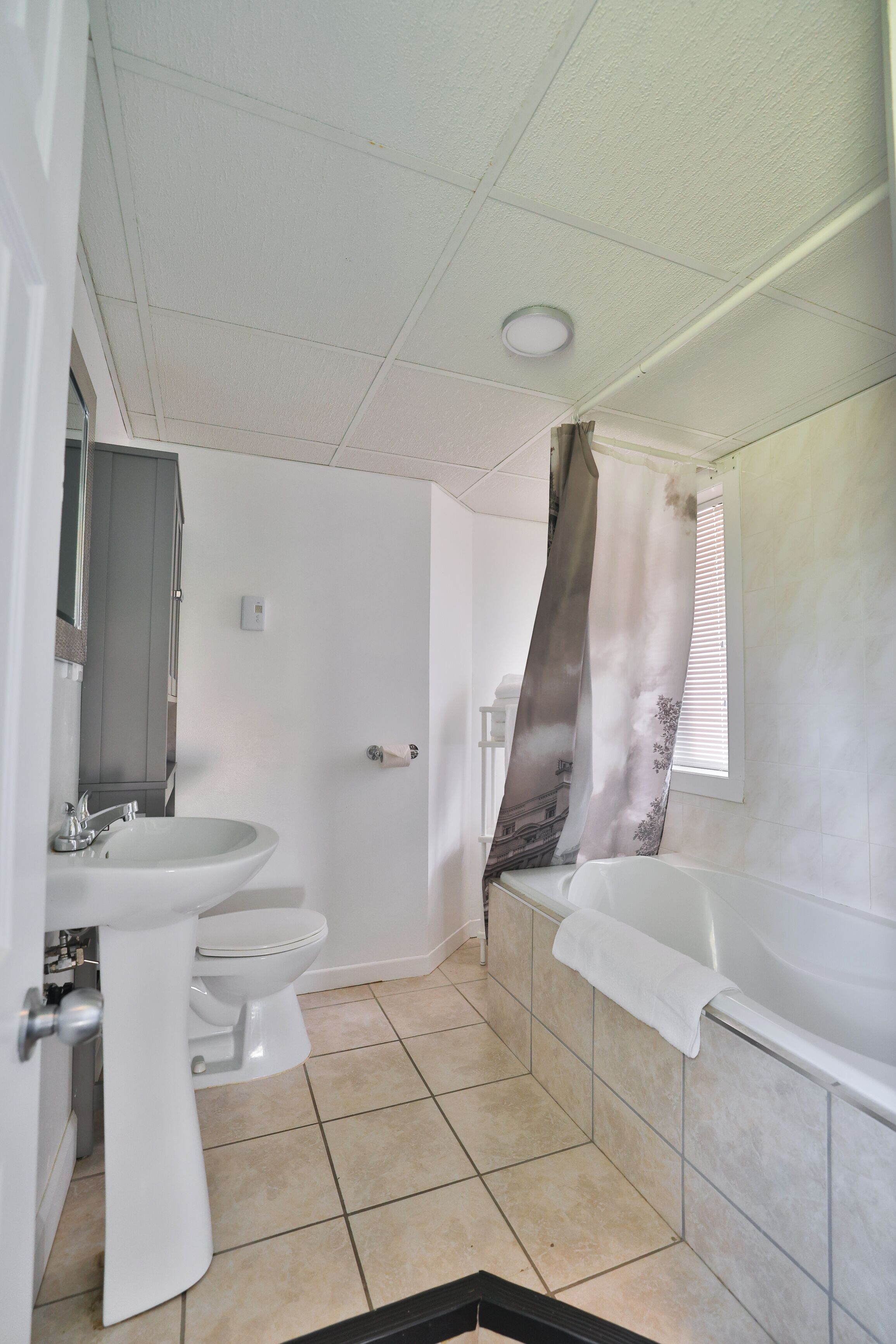 A bathroom with a toilet, sink, and bathtub.