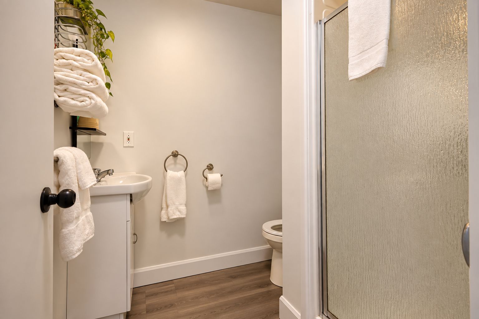 A bathroom with a sink, toilet, and a shower area.