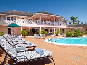 Área da piscina com espreguiçadeiras e piscina.