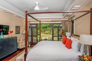 A four-poster bed with a view of a garden through large windows. - Tek Time, Montego Bay 5BR (Montego Bay)