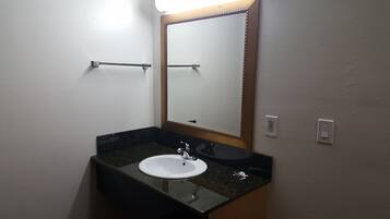 A bathroom with a white sink, a mirror with a wooden frame, and a towel rack.