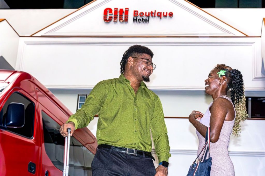 Mies ja nainen seisovat rakennuksen edessä, ja rakennuksen kyltissä lukee: »Citi Boutique Hotel».