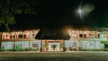 Vista frontal de la propiedad por la tarde o noche