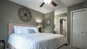 A bedroom with a bed, a ceiling fan, a wall clock, and a door. - Less than 2 miles to Downtown and sleeps 6.  (Athens)