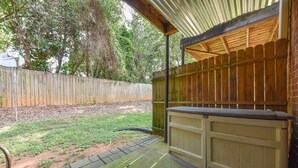 A covered patio area with a wooden fence, a concrete pathway, and a beige outdoor seating area. - Less than 2 miles to Downtown and sleeps 6.  (Athens)
