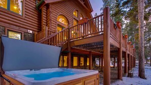 Una baita di legno con idromassaggio e un balcone.