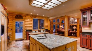 Interno di una baita in legno con cucina, zona pranzo e soggiorno.