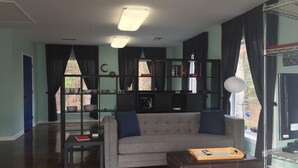 Una sala de estar con un sofá, una mesa de centro, una estantería y un televisor.