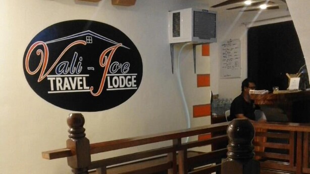 En skylt som visar vägen till ett enkelt hotell eller vandrarhem, en trätrappa och en bar.