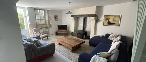 A living room with a fireplace, a sofa, a coffee table, and a television.