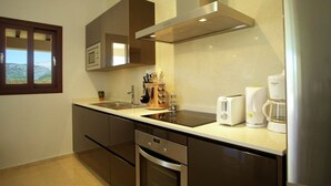 Eine moderne Küche mit Edelstahlgeräten, einem Einbauofen und einer Kaffeemaschine.