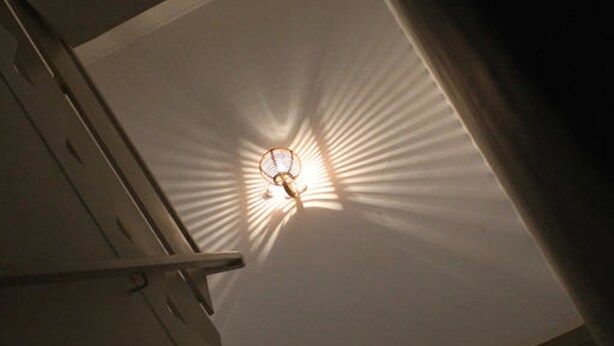 A ceiling with a light fixture casting a radial pattern of light. - Gen-Ji Cottage (Malacca City)