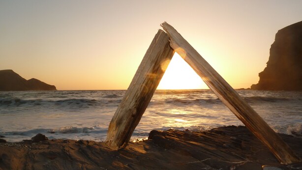 A wooden structure forming a triangle on a rocky beach with the ocean and cliffs in the background. - The Old Shippon, Crackington Haven, Bude, Cornwall, walk to the Beach Pub. (Crackington Haven)