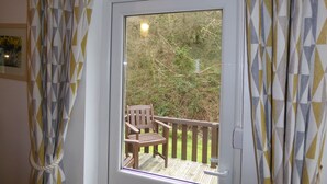 A room with a window overlooking a deck with wooden furniture. - The Old Shippon, Crackington Haven, Bude, Cornwall, walk to the Beach Pub. (Crackington Haven)