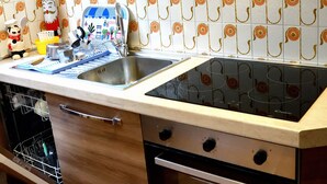 A kitchen with wooden cabinets, a stainless steel sink, and a built-in oven. - Chalet Jacqueline & Franco - Three-room apartment very close to the ski slopes (Sauze d'Oulx)