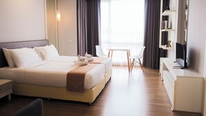 A modern hotel room with a large bed, a desk, a chair, and a balcony with curtains. - The Kannas Hotel (Chiang Mai)
