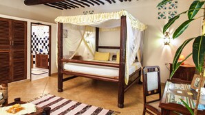 A four-poster bed with a canopy, wooden furniture, and a tiled floor. - Large luxury beachside villa with a pool, guesthouse, cook, gardener, and maid (Diani Beach)