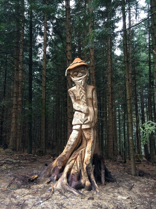 A wooden sculpture in a forest.