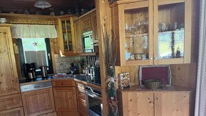 A wooden kitchen with a built-in oven, a coffee maker, and a microwave. - Cabin with great location and view of the Bischofsmütze Mountain (Annaberg im Lammertal)