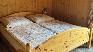A wooden bed with a headboard, a wooden ceiling, and a wall-mounted light fixture.