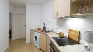 A compact kitchen with a washing machine, a toaster, a cutting board, and a coffee maker. - with underfloor heating and WiFi (Berlin)