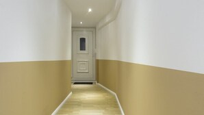 A narrow hallway with wooden flooring and white walls with a beige stripe. - with underfloor heating and WiFi (Berlin)