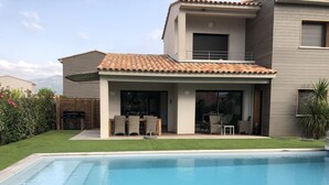 A modern house with a swimming pool, a patio with outdoor furniture, and a view of the mountains. - Luxury villa with private pool 500m from the beach St Cyprien Porto Vecchio (Lecci)