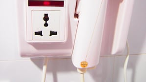 Un ioniseur portatif rose, de modèle compact 1300, muni d’une prise et d’une étiquette de certification.