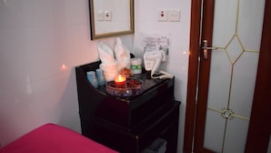 Une salle de bain équipée d’un miroir, d’un lavabo, d’un distributeur de serviettes, d’un téléphone et d’une poubelle.