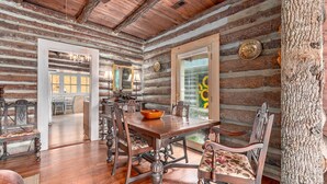 A rustic log cabin interior with a wooden dining table, chairs, and a chandelier. - TWO Amazing Log Cabins, Storybook Setting, Hot Tub, WiFi, Mountain Views Pets Ok (Gerton)