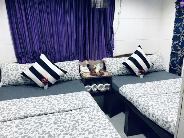 A modern living room with a sofa set, a small table with a phone and a candle, and a purple curtain. - Premium Lounge (Kowloon)