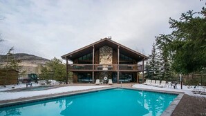 Un edificio de dos plantas con una piscina en la parte delantera.