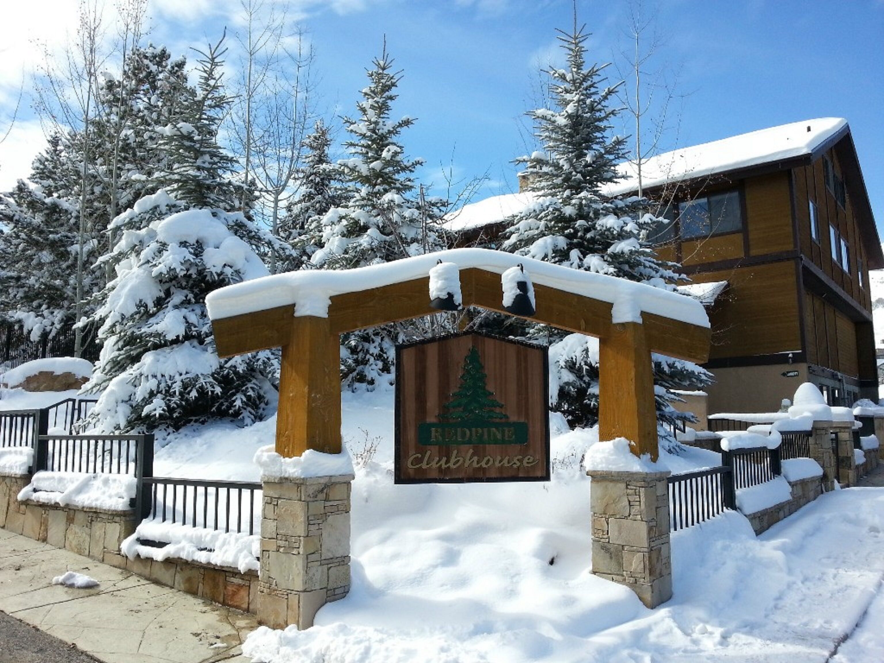 A wooden sign with a snow-covered pine tree logo and the text "Eddie's Cabinhouse".