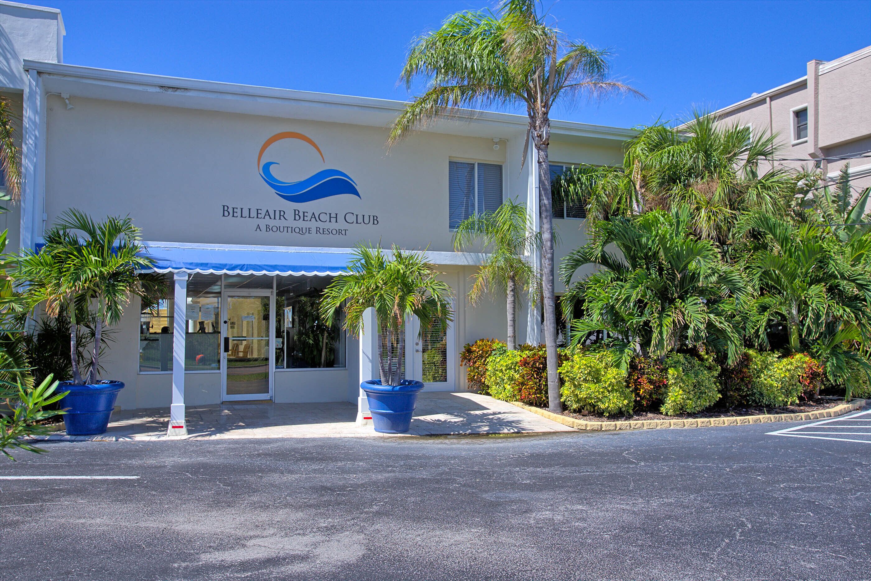 Un edificio con un cartel que dice 'Belleair Beach Club A Boutique Resort' y una entrada cubierta.
