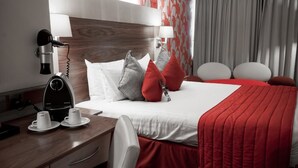 A hotel room with a bed, a desk with a coffee maker, and a hairdryer. - Traveller's Hostel (Kowloon)
