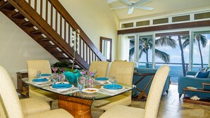 A dining area with a glass table, chairs, and a view of the ocean. - STUNNING OCEANFRONT * Poipu's Best View * New Air Conditioning throughout (koloa)