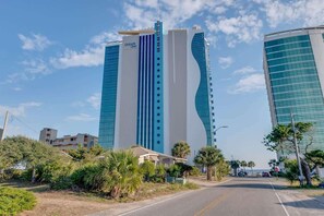 A modern hotel with a prominent vertical design, featuring a blue and white color scheme. - New Modern, Direct Oceanfront, Boardwalk, Views! (Myrtle Beach)