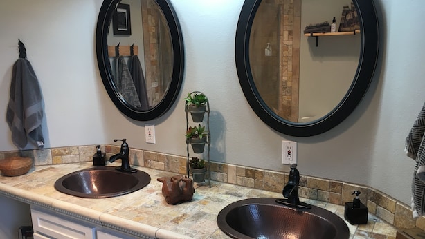 A bathroom with two sinks, a mirror, and a towel rack.