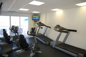 A gym with treadmills, stationary bikes, and elliptical machines.