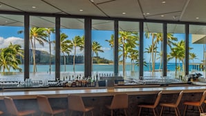 Un espace bar avec vue sur la plage et les palmiers.