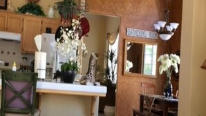 Un grand espace de vie comprenant une cuisine, une table à manger et un panneau indiquant qu’il s’agit d’une salle de réunion.