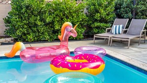 Una piscina con flotadores de unicornio inflable y rosquillas.