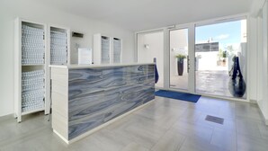 A reception area with a marble counter, storage cabinets, and a glass door leading outside.