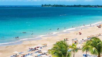 Na praia, espreguiçadeiras, toalhas de praia 