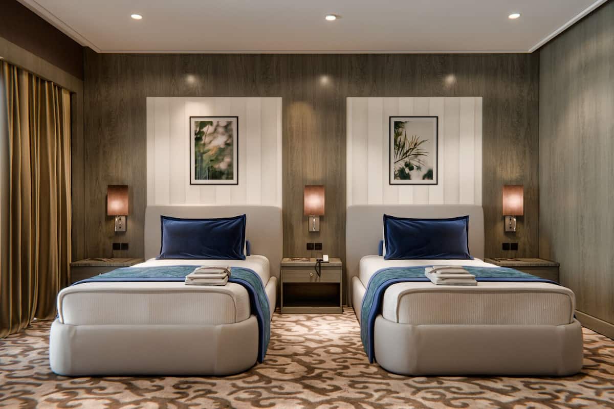 Une chambre d’hôtel avec deux lits, une moquette à motifs et des œuvres d’art accrochées aux murs.