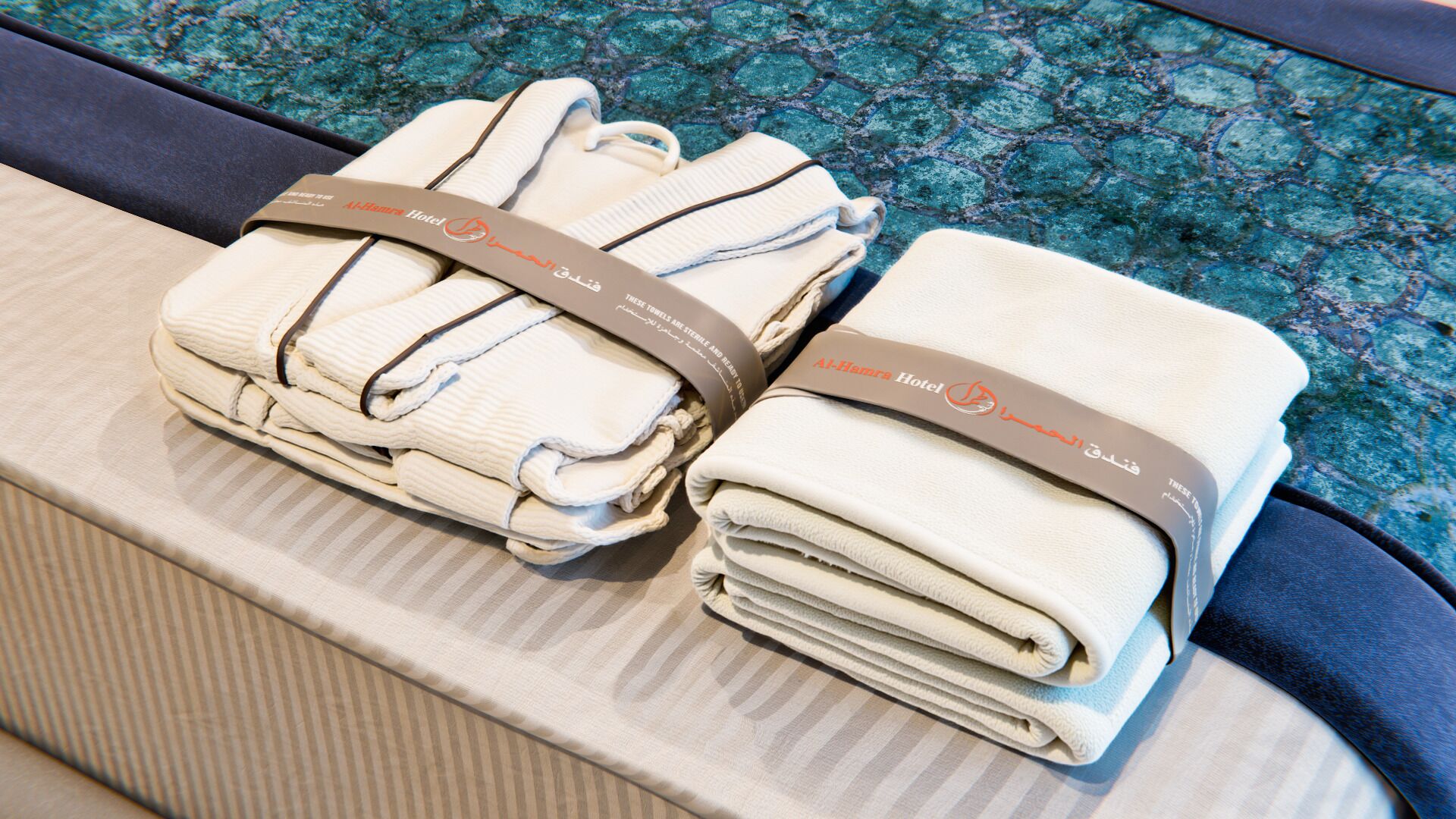 Neatly folded towels with a hotel logo, placed on a cushioned surface.