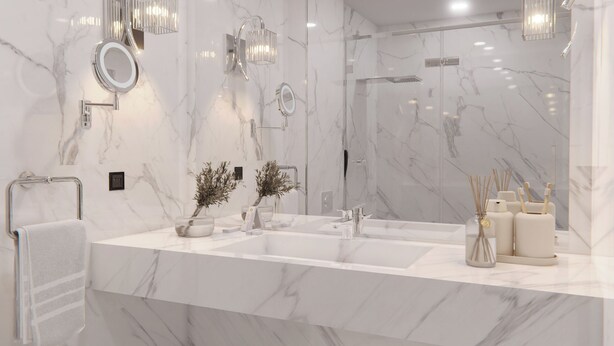 A modern bathroom with marble countertops, a large mirror, wall-mounted lights, and a shower area.